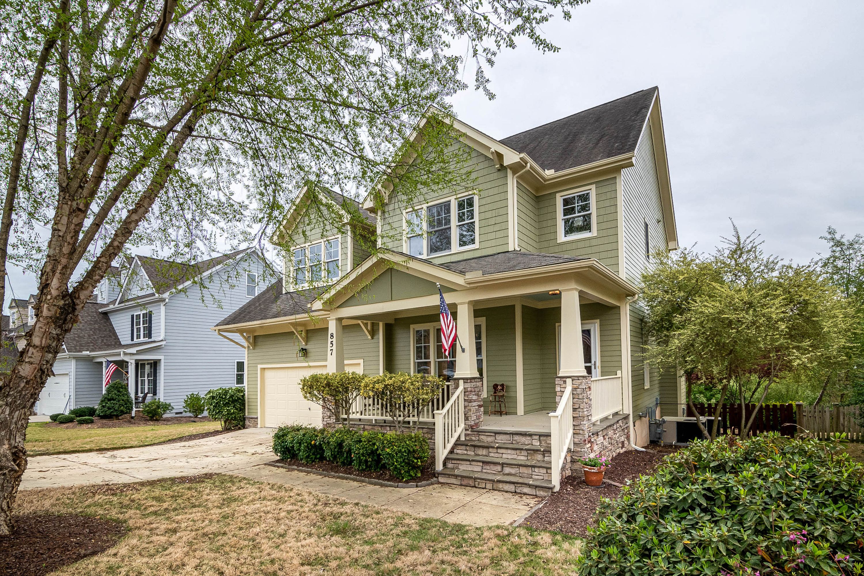 A welcoming two-story home with an American flag on its front porch